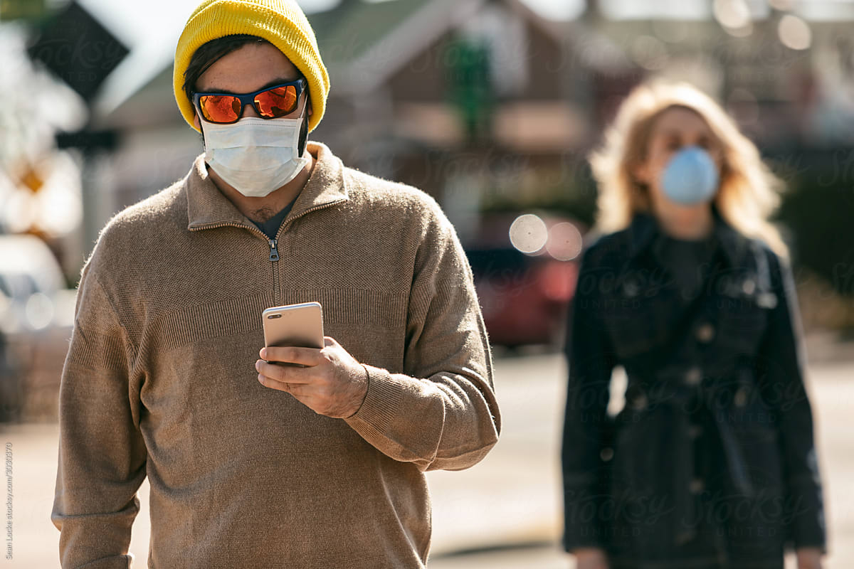Virus: Hipster Man Walks While Wearing Mask And Using Cell Phone