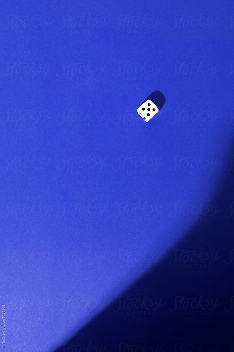 Dice on a royal blue background with interesting light