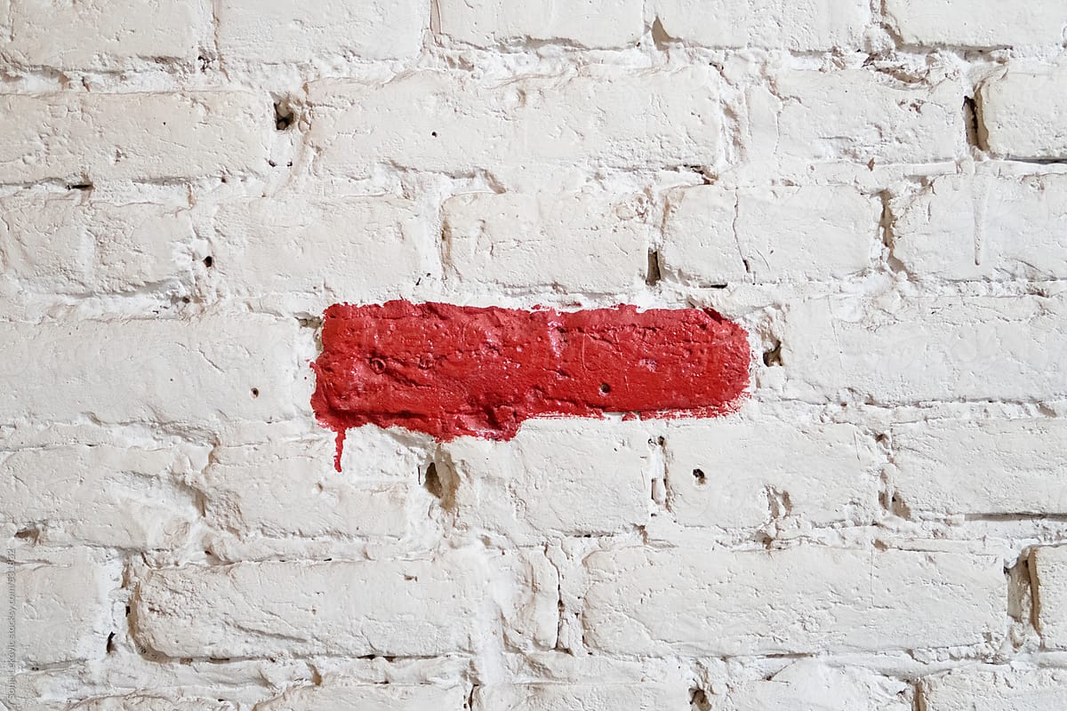 red painted line on a white brick wall