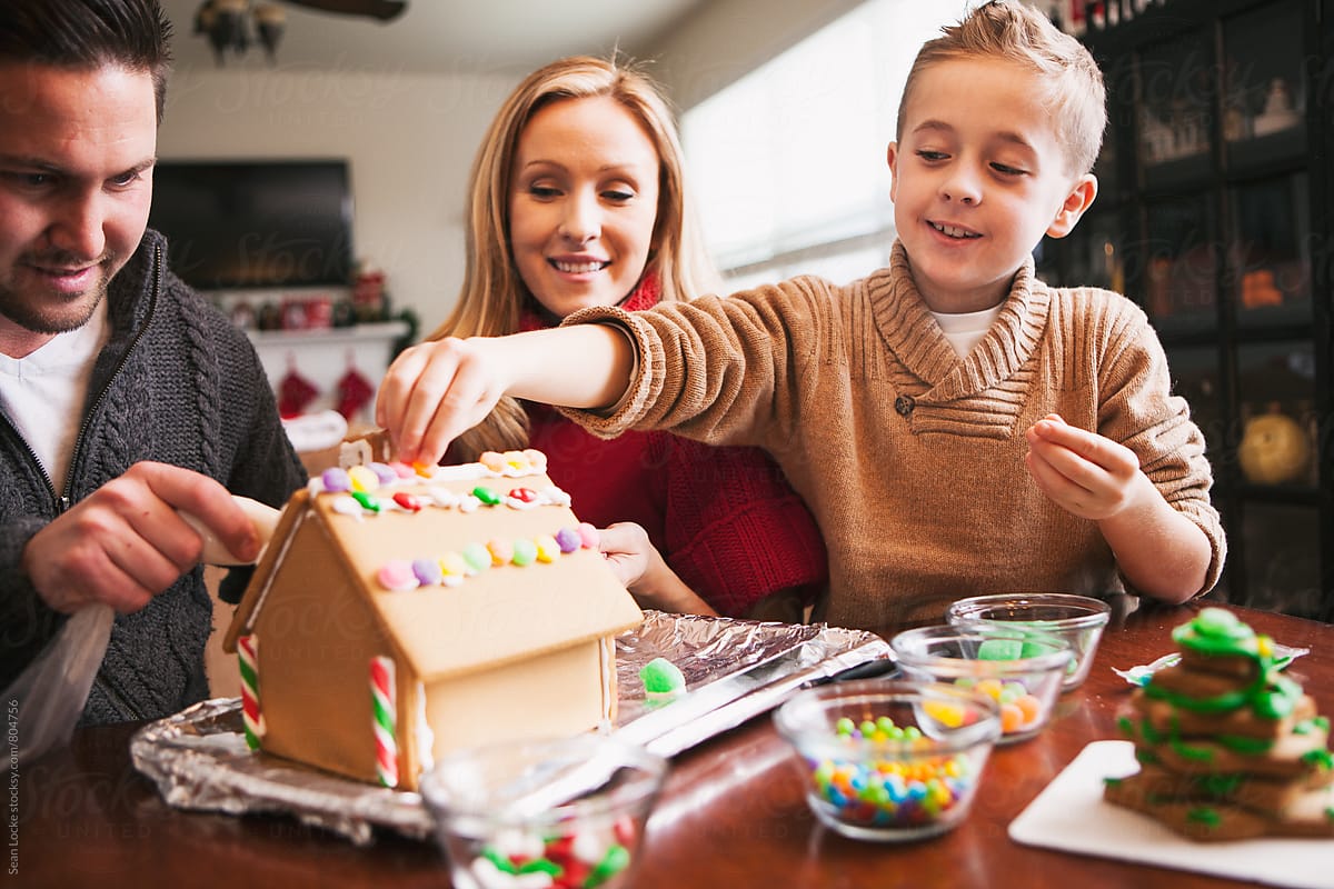 Christmas: Boy Having Fun Decorating Gingerbread House
