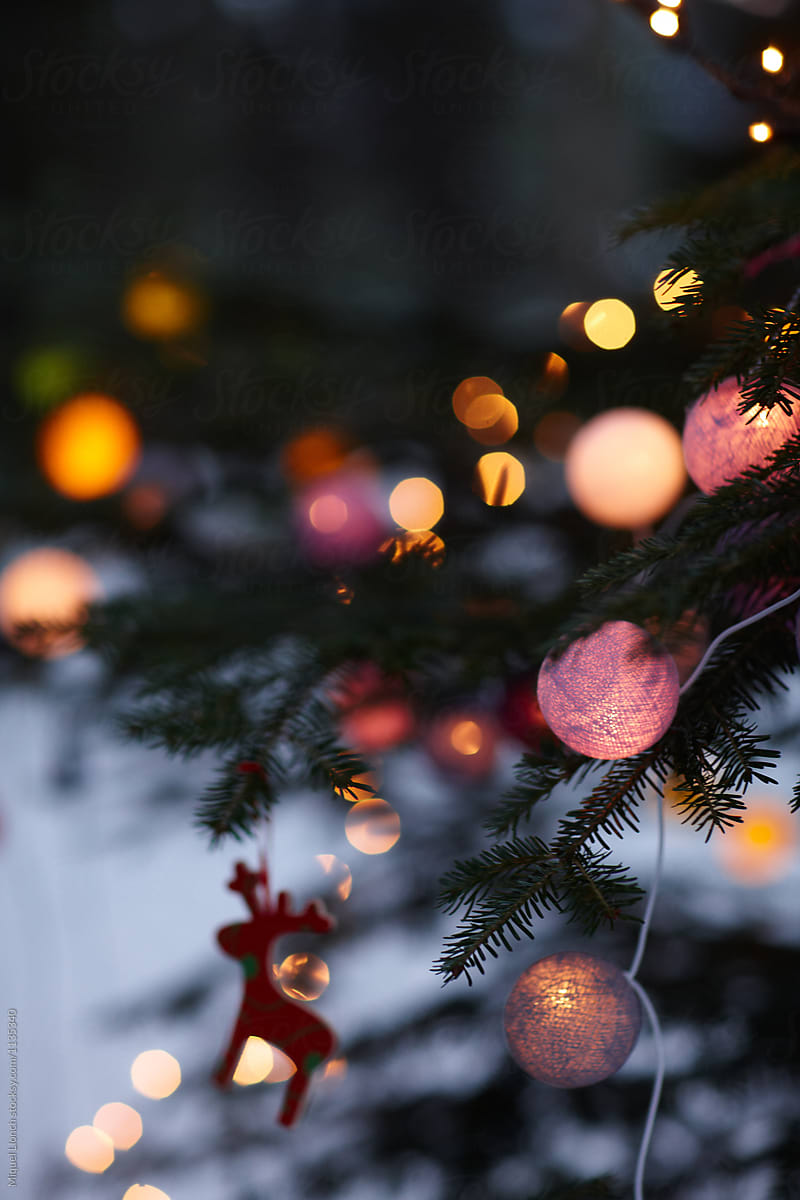 Christmas tree with lit balls and ornaments outdoors