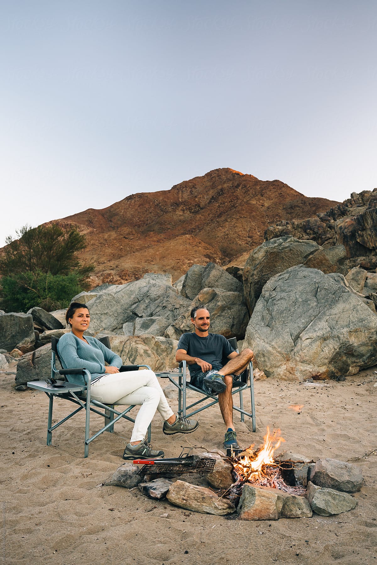 camping couple by a campfire outdoors