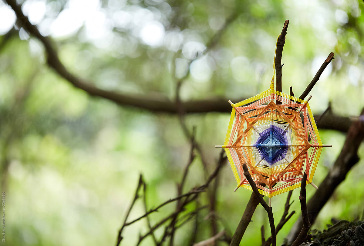 Hand-woven dream catcher graphic, in a natural wood environment.