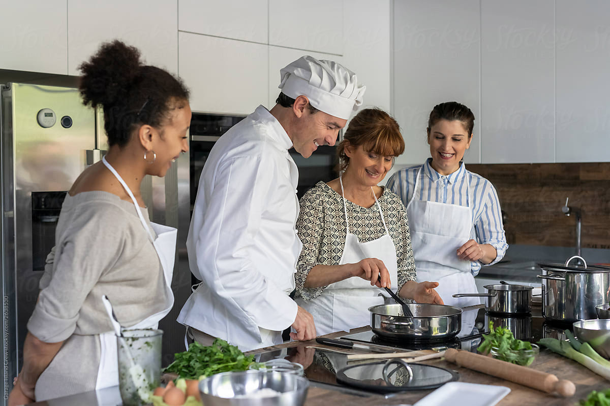 Chef and women cooking together in a kitchen class