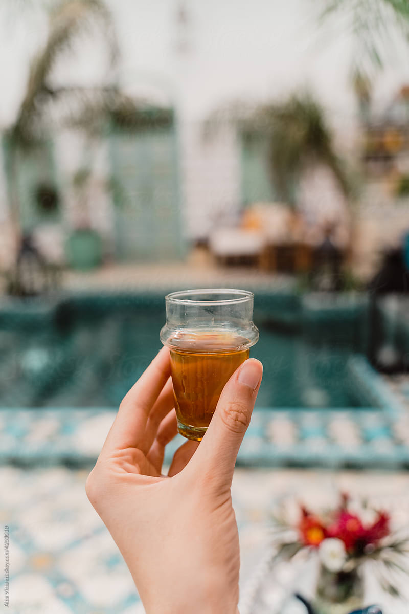 Close-up of woman holding typical moroccan tea by pool
