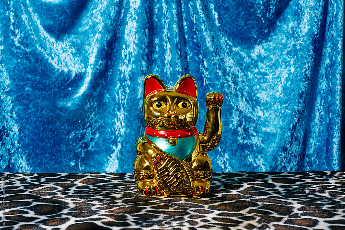 golden chinese lucky cat on an animal print fabric