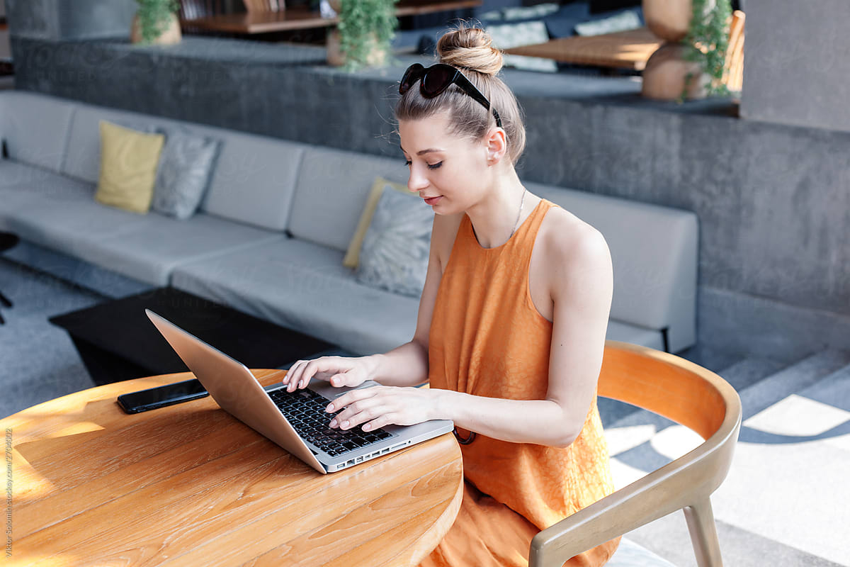 Blonde young woman freelancer are working with laptop outdoor in summer