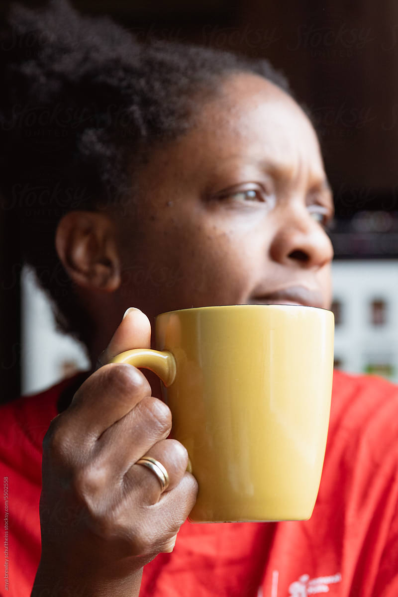 Black woman holding a mug of coffee or tea