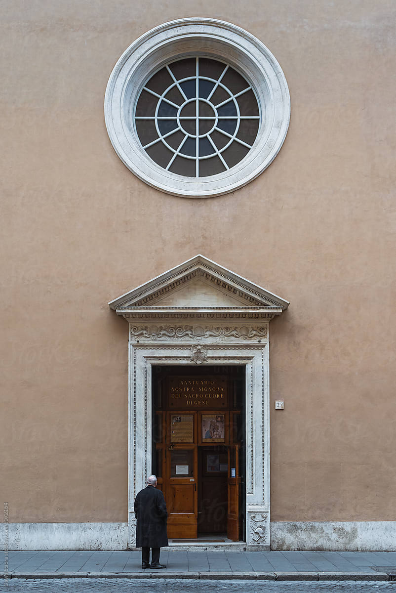 Man standing in front of the entrance to the church of Saint Ives