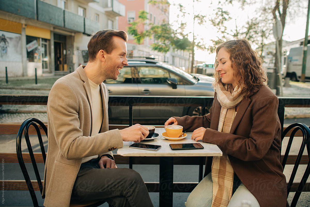 Couple on a first date having coffee in outdoor cafe