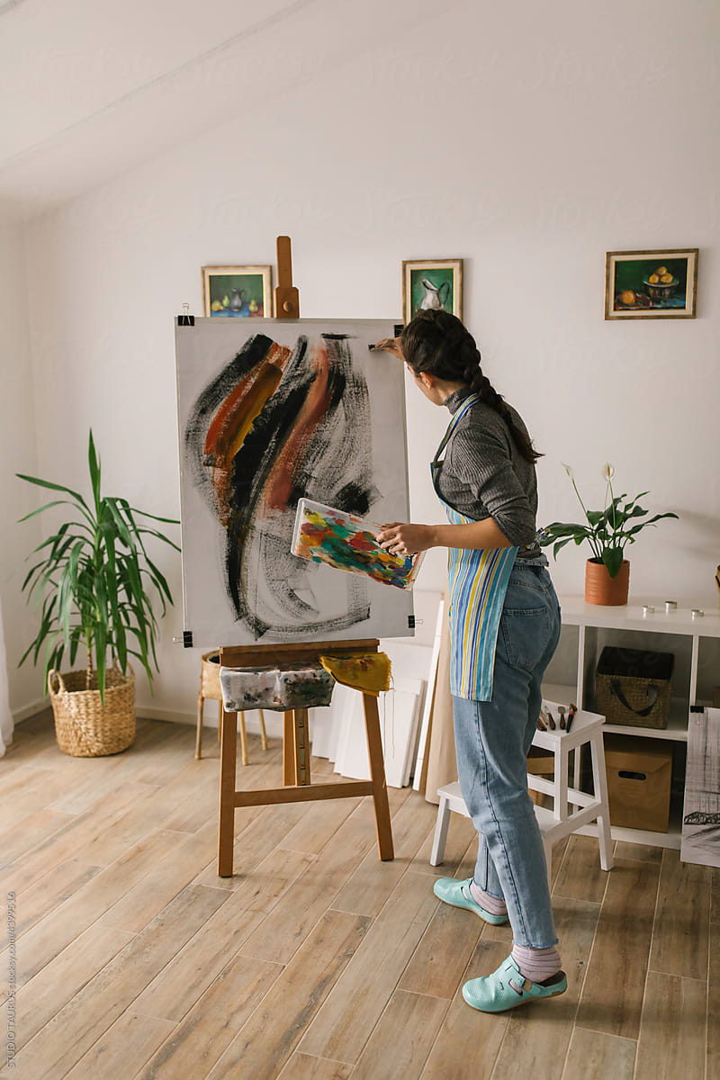 Female painter in art studio painting on canvas