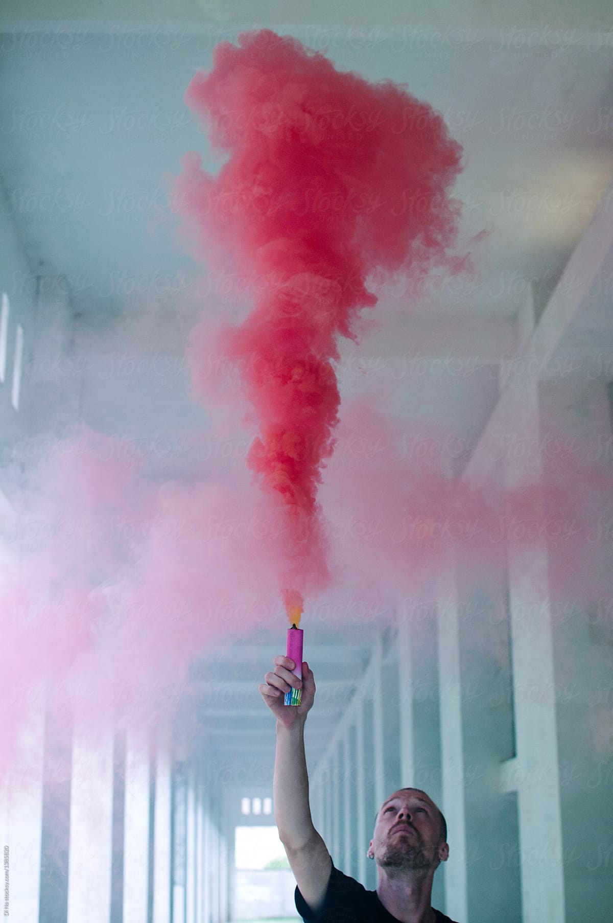 Young man with pink smoke bomb