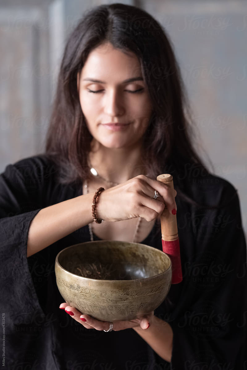 Brunette playing singing bowl during meditation session