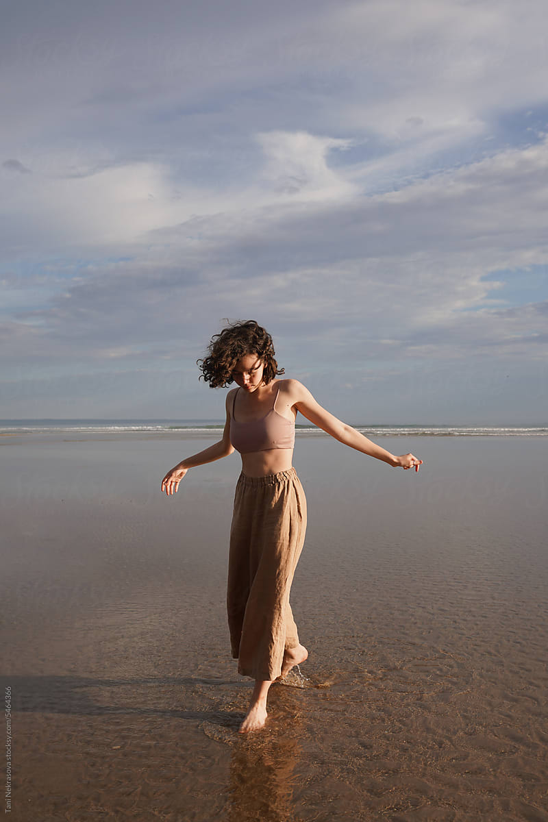 A young curly-haired girl walks by the Atlantic ocean