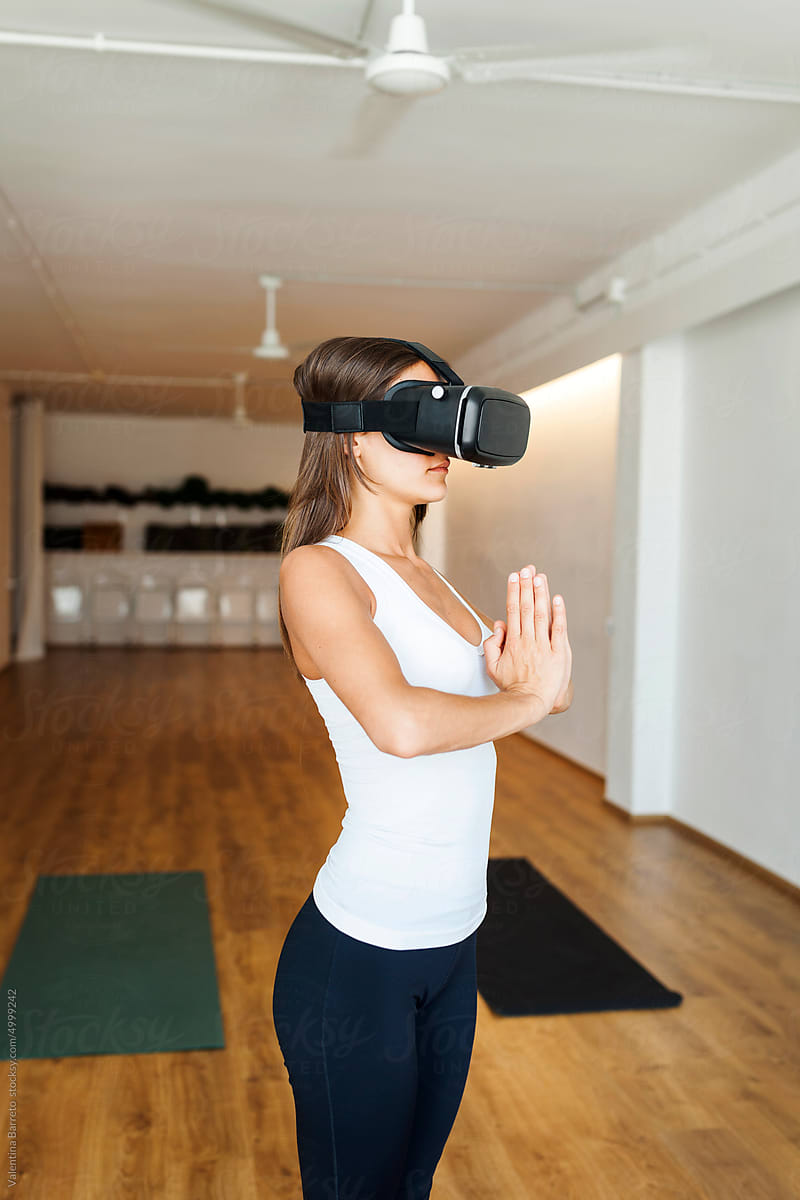Woman practicing yoga with VR glasses