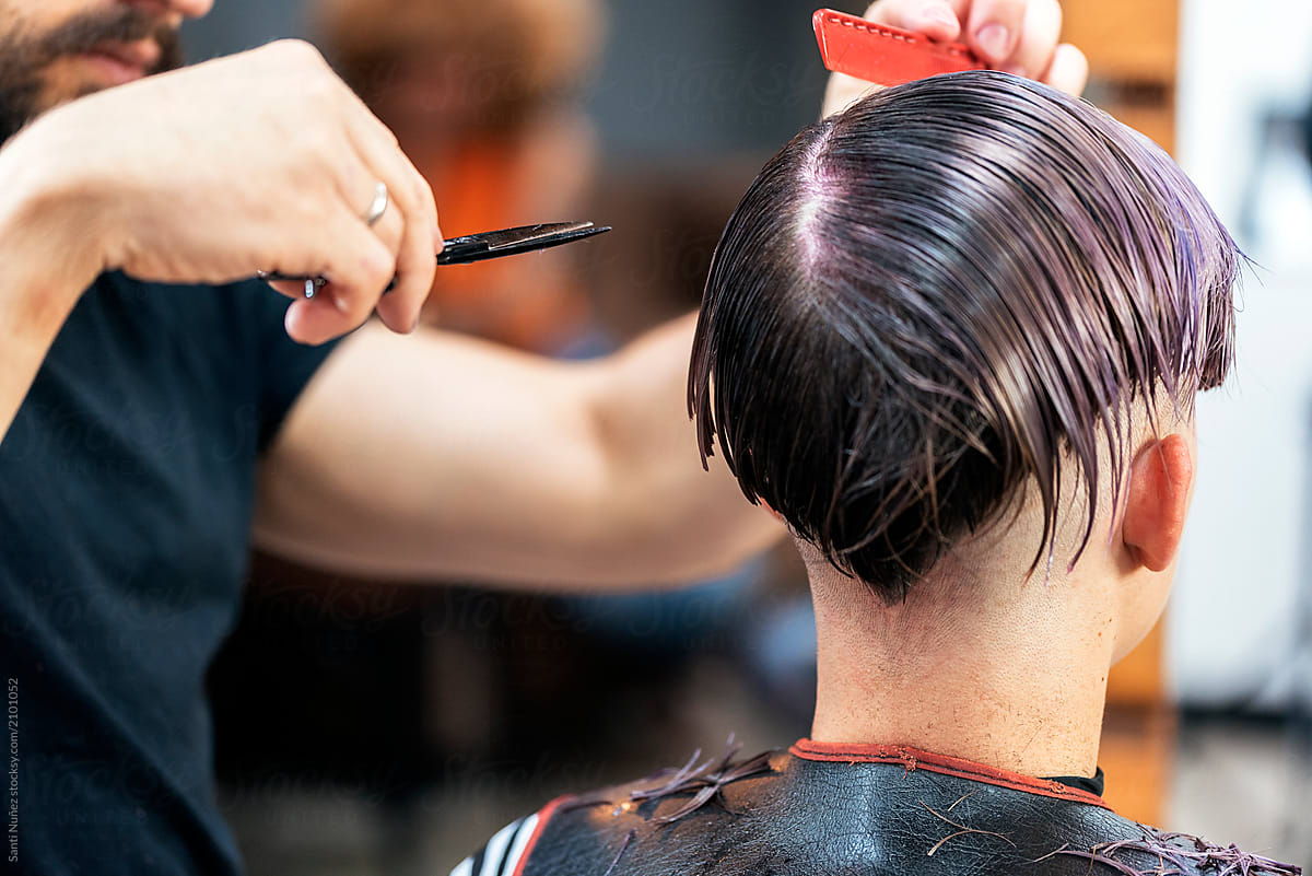 Unrecognizable woman getting haircut by hairdresser in the beauty salon