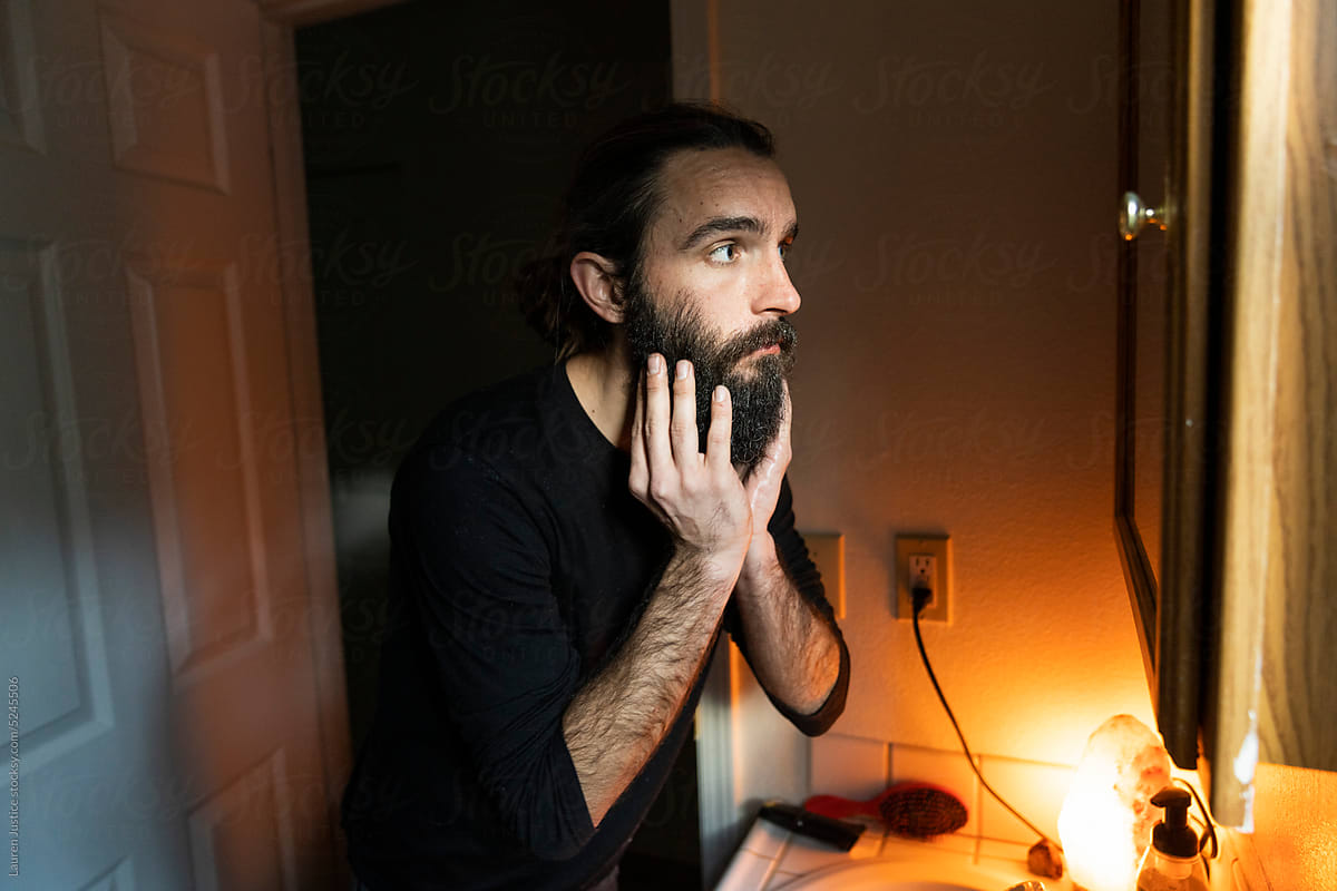 Man uses beard oil on long hair and beard