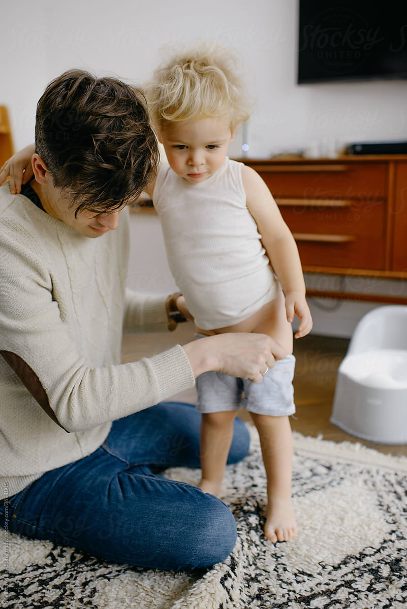 Baby boy potty training indoors with dad