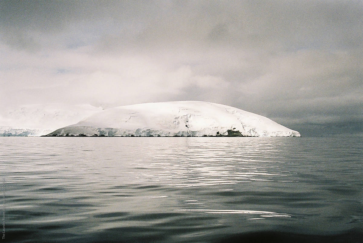 White Landmass of Ice on Rock in Black Antarctic Waters