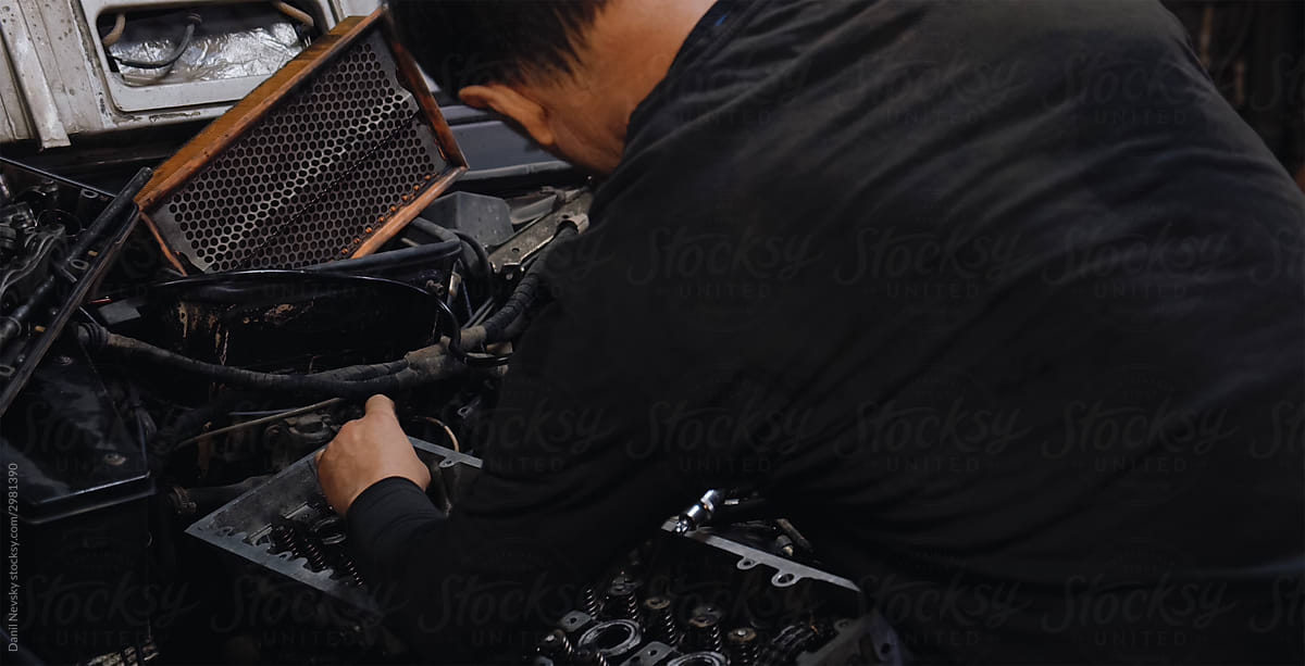 Crop mechanic fixing car engine