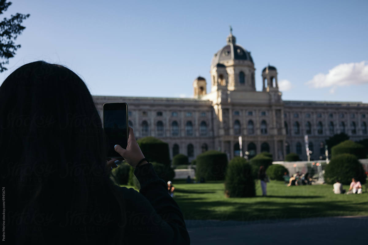 Woman taking photos with smartphone in Vienna