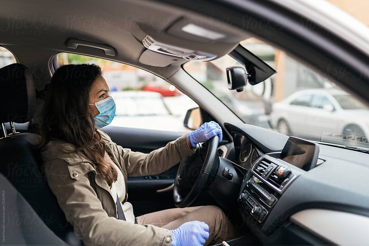 Woman wearing protective mask driving