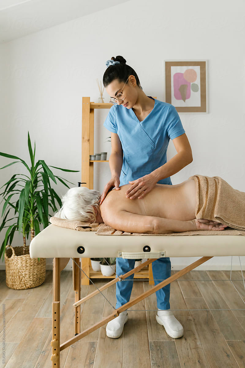 Senior woman having professional massage at spa