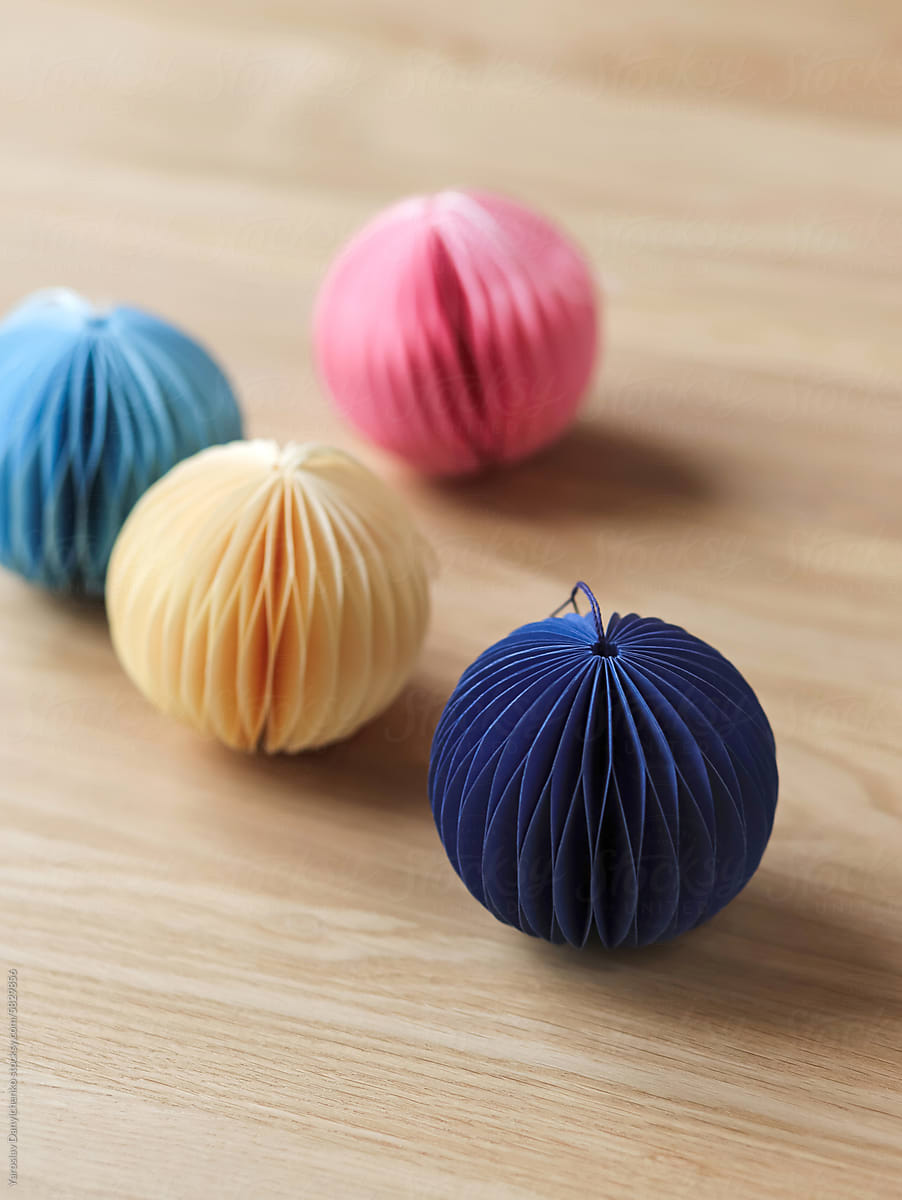 Tissue paper balls in pink, blue and ivory colours on wooden desk