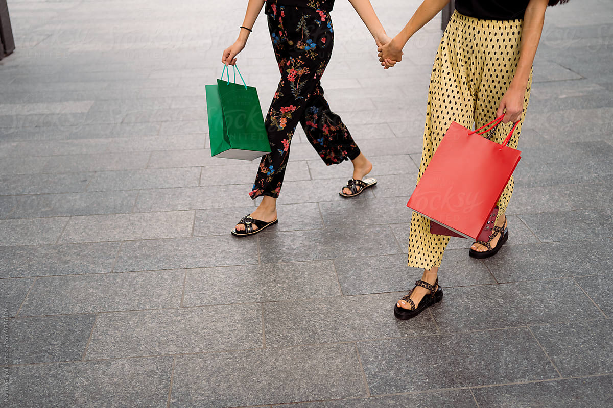 Girls hand in hand with shopping bags