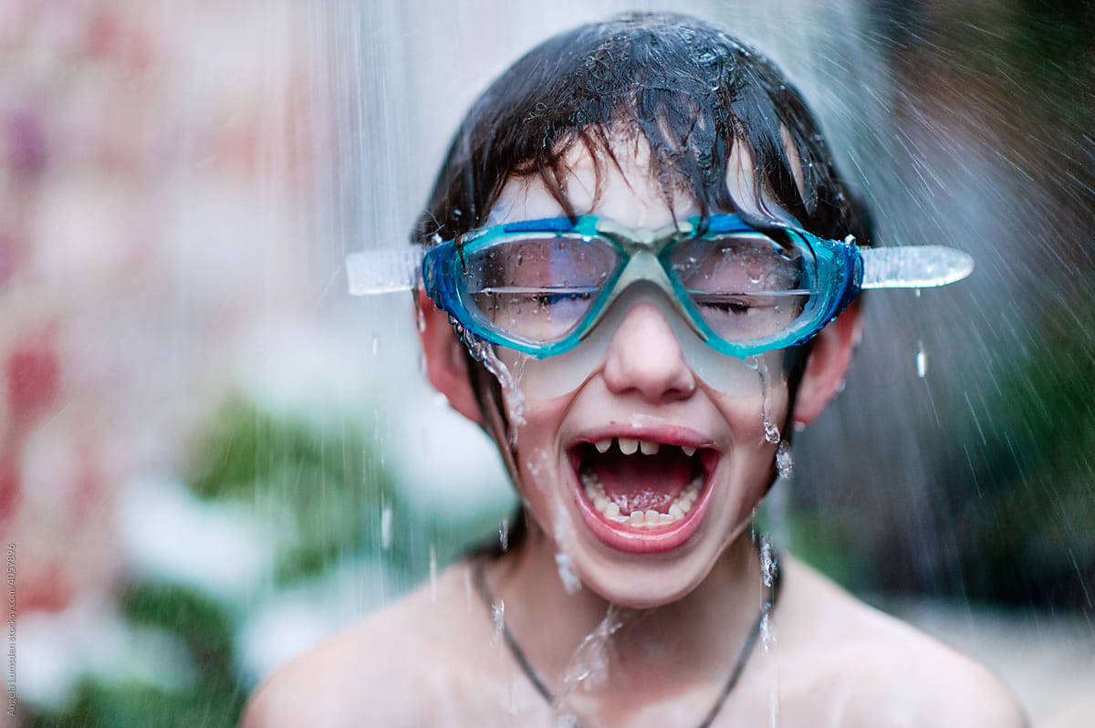 Goggles and fun as child has an outdoor shower