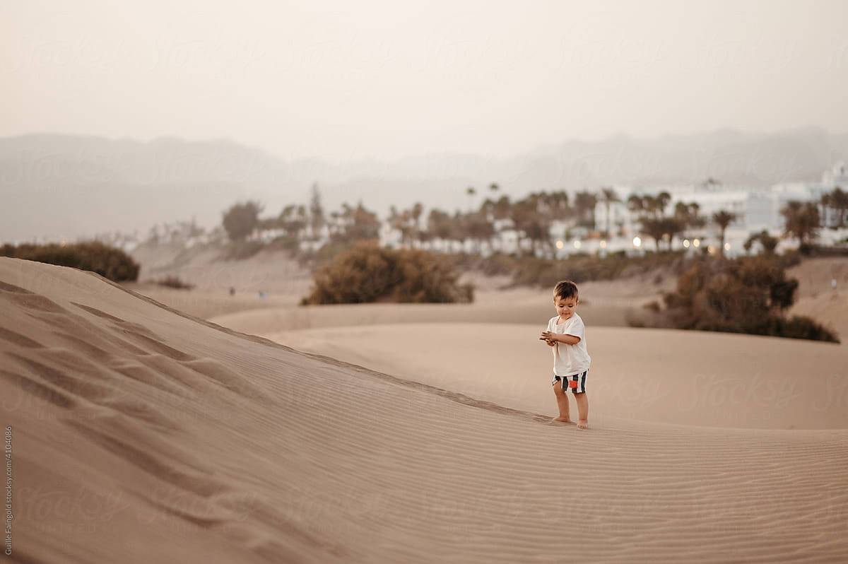 Cute toddler boy in sandscape.