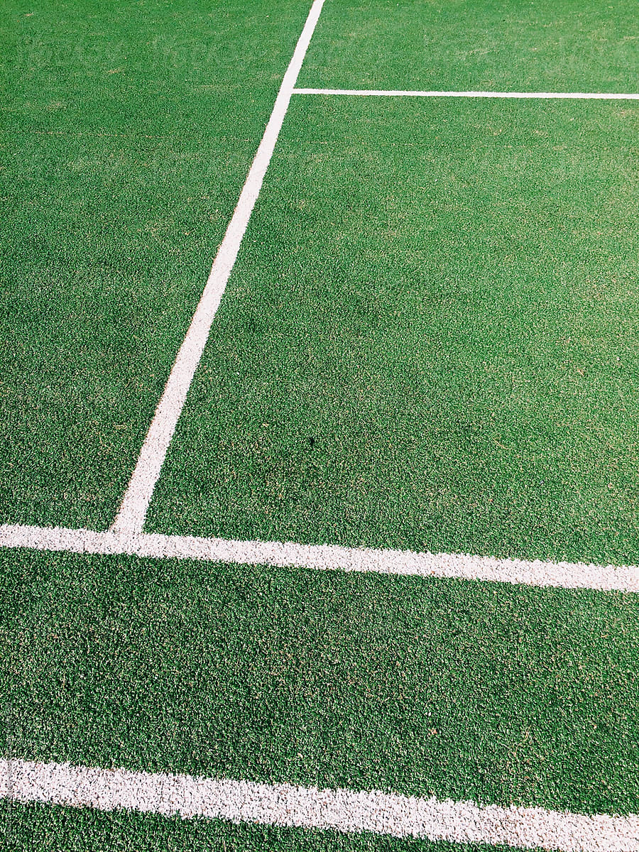 Photo of grass sport football field with geometric graphic white lines