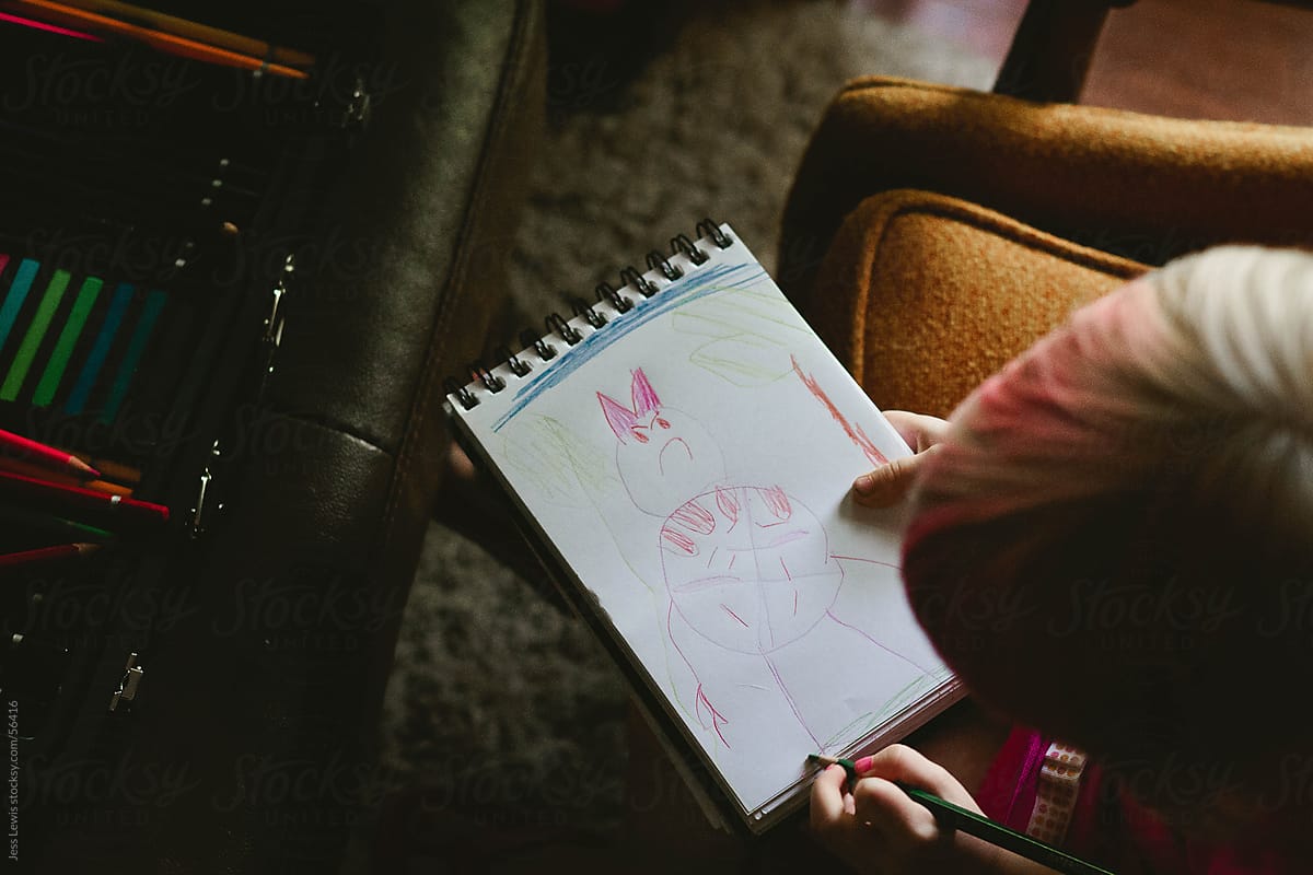 young girl drawing picture in a notebook