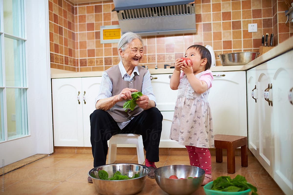 senior asian woman with her great granddaughter in the kitchen