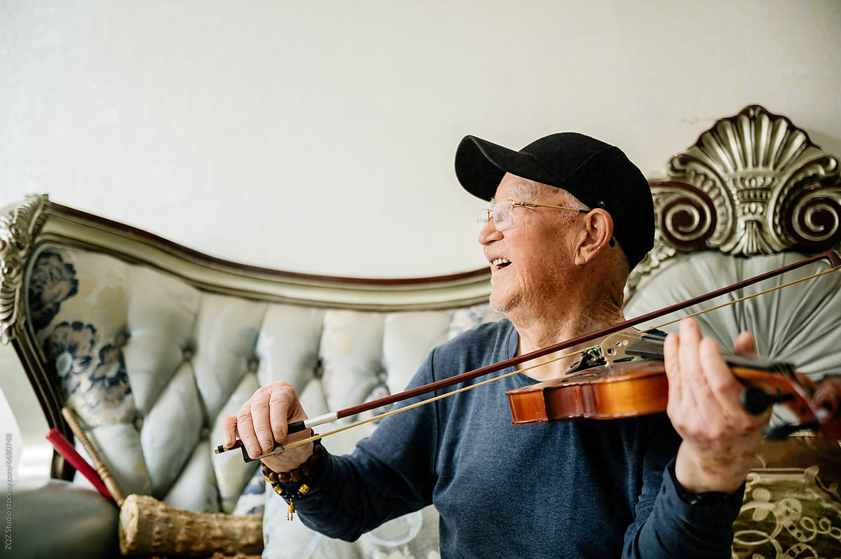 Senior man playing violin at home