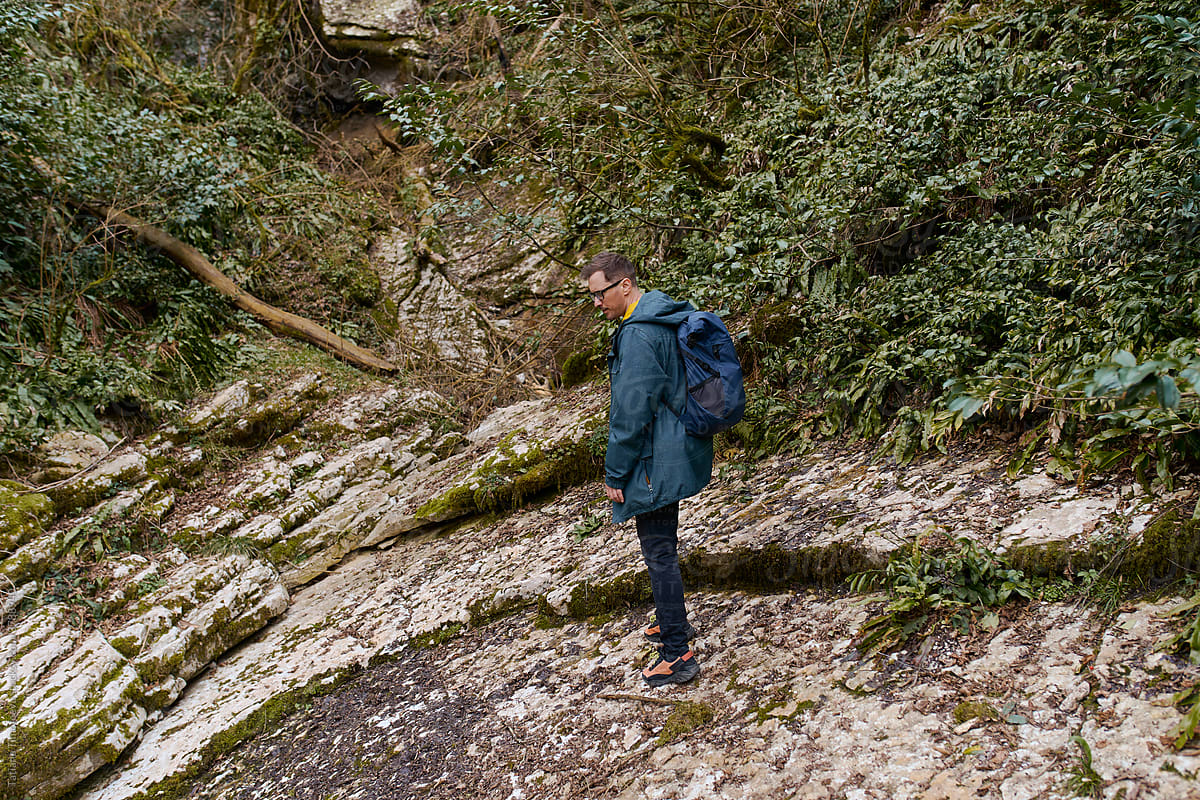 a man walking with a backpack in the woods
