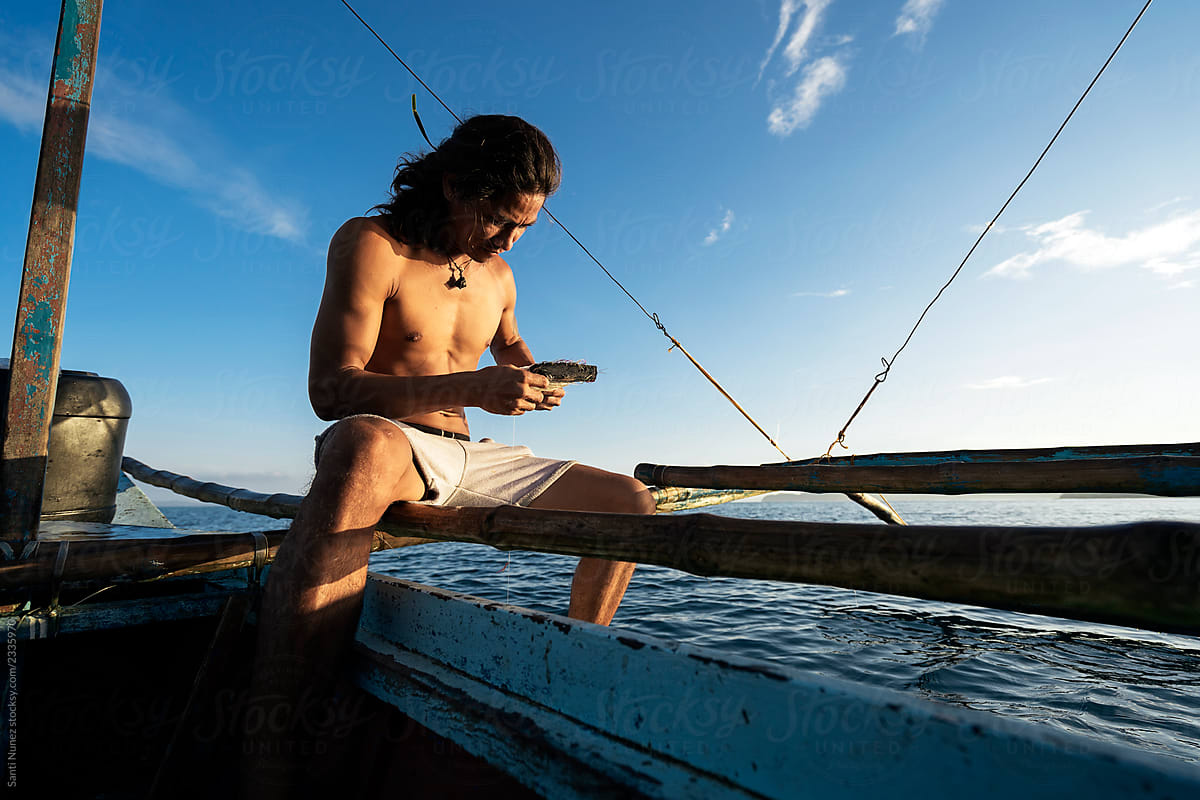 Asian Man Fishing On Boat by Stocksy Contributor Santi Nuñez - Stocksy