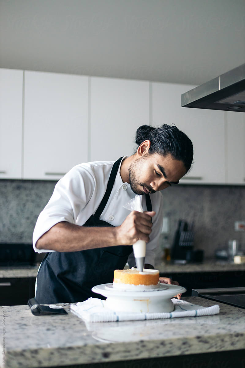 pastry chef pouring meringue on a cake