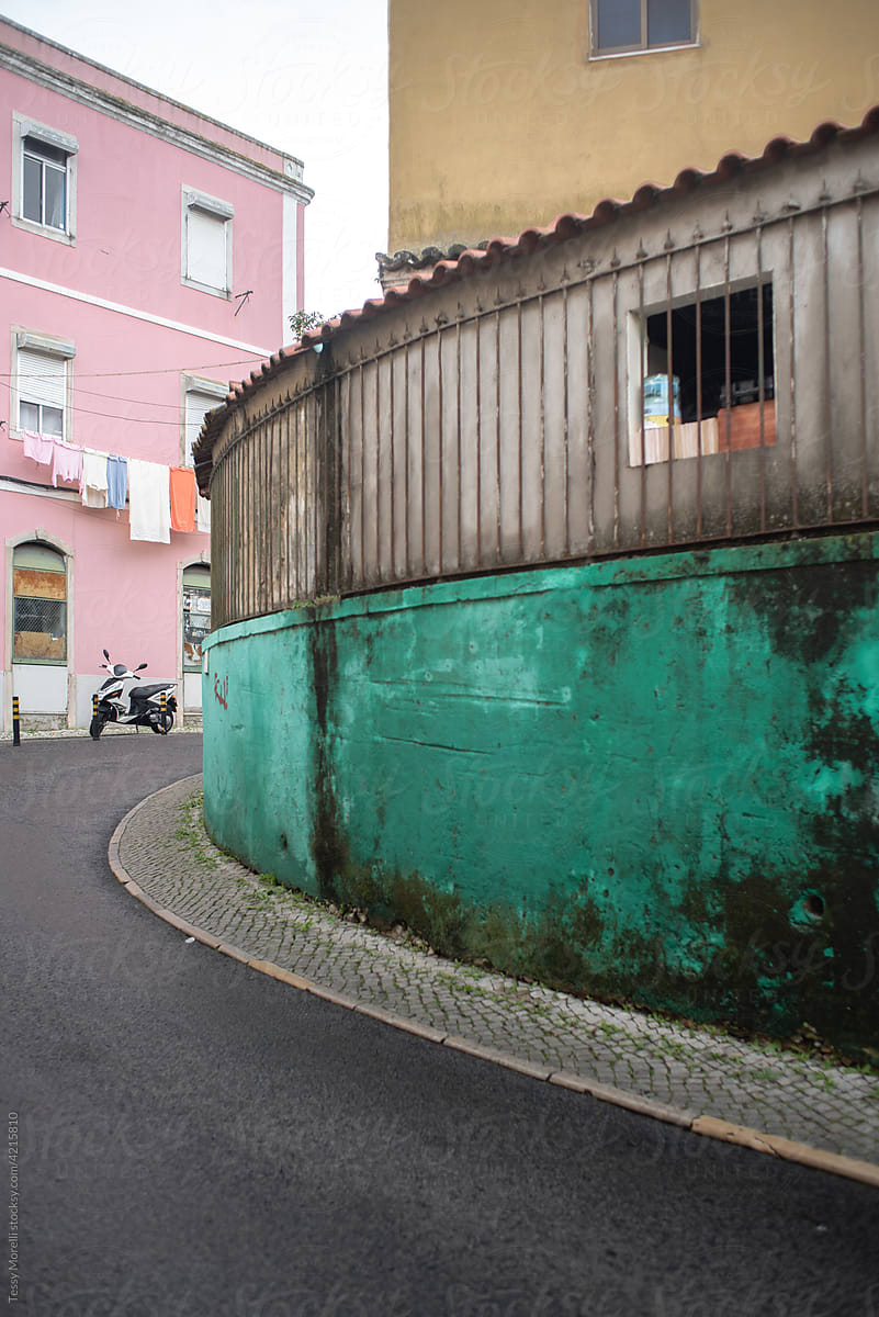 Curve street with wall painted in deep green