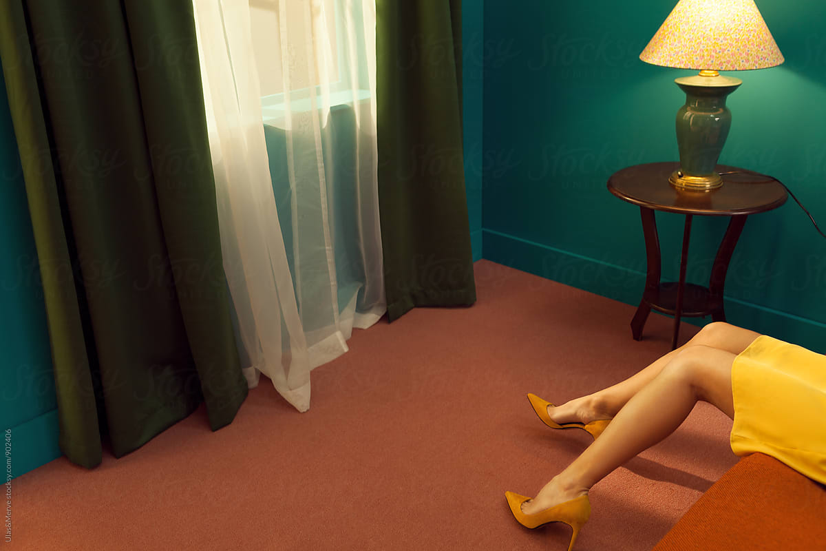 legs of a woman lying down on a bed in a retro room