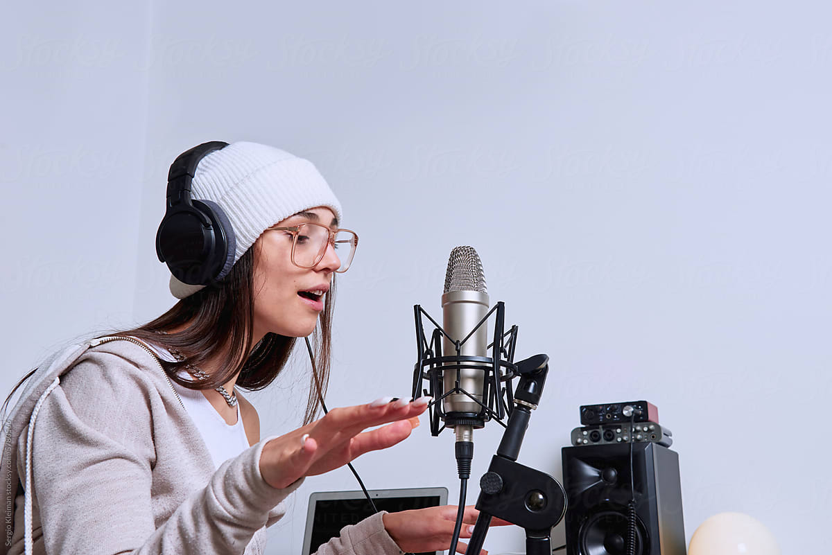 Young latin woman raps into microphone.