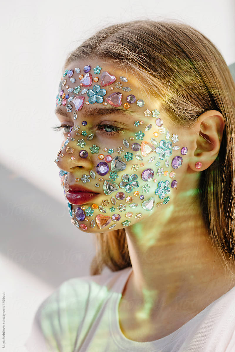 Teenage girl with face decorations in unusual light