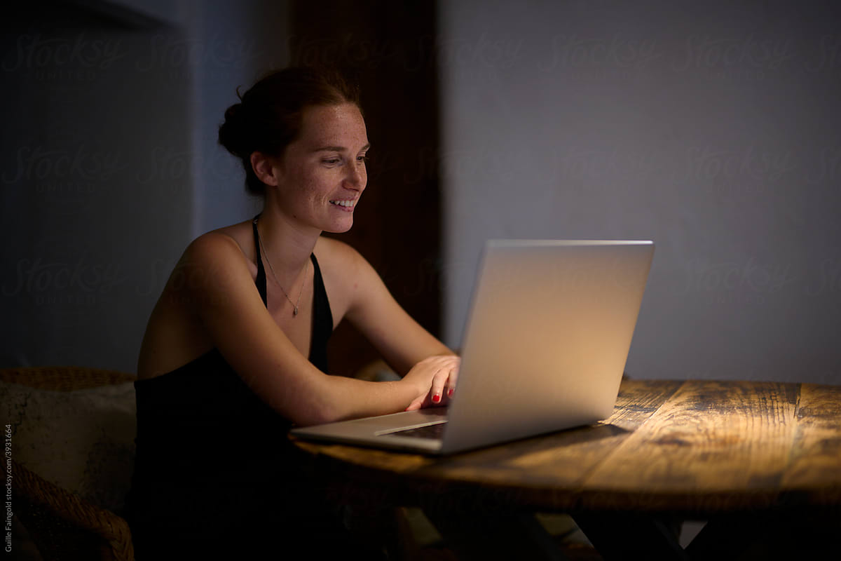 Smiling woman using laptop.