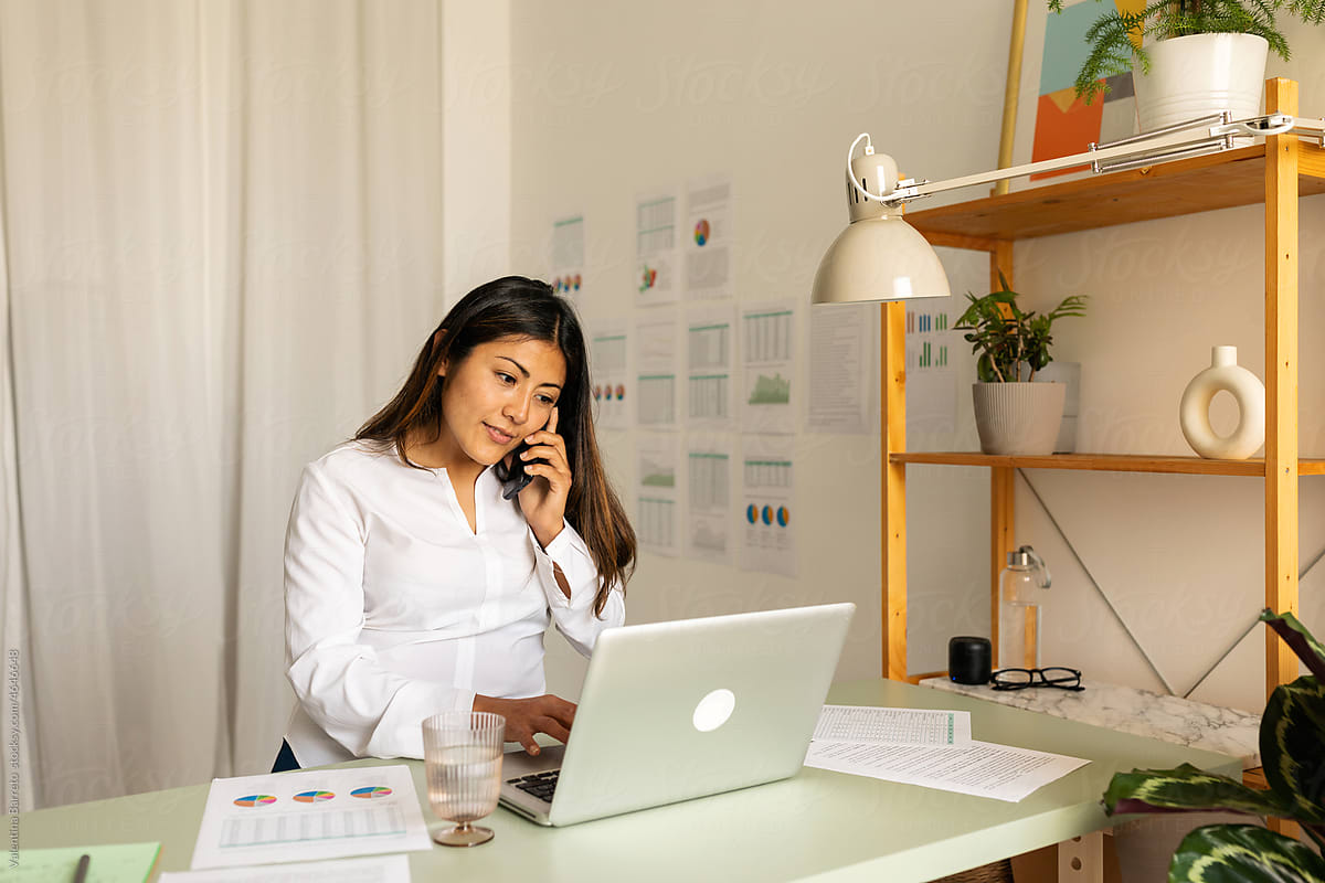 Mixed race business woman calling by phone at office