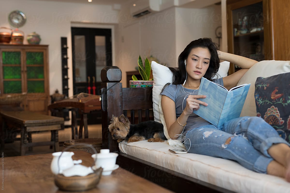 Singaporean woman on her sofa reading