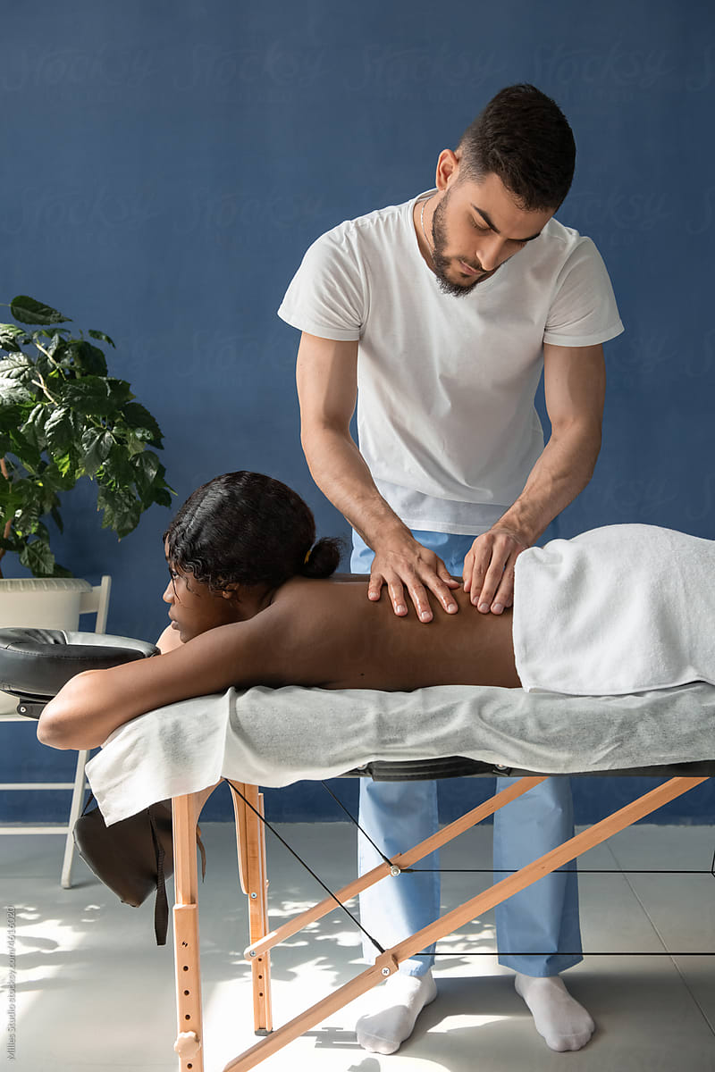 Masseur pinching back of client