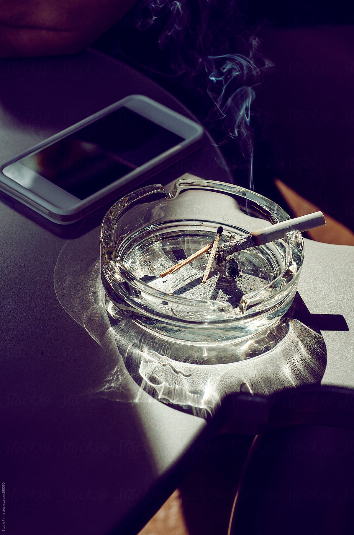 ashtray with smoking cigarette on the table