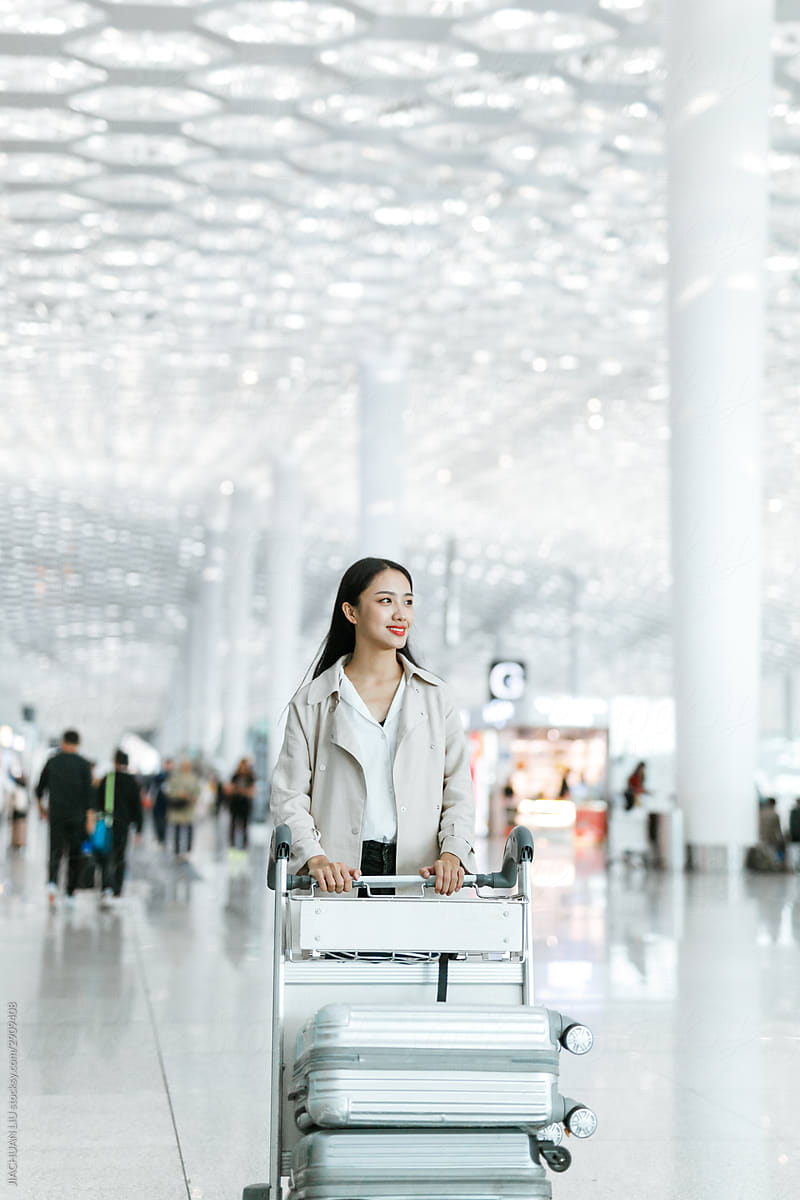Woman pushing luggage through an airport