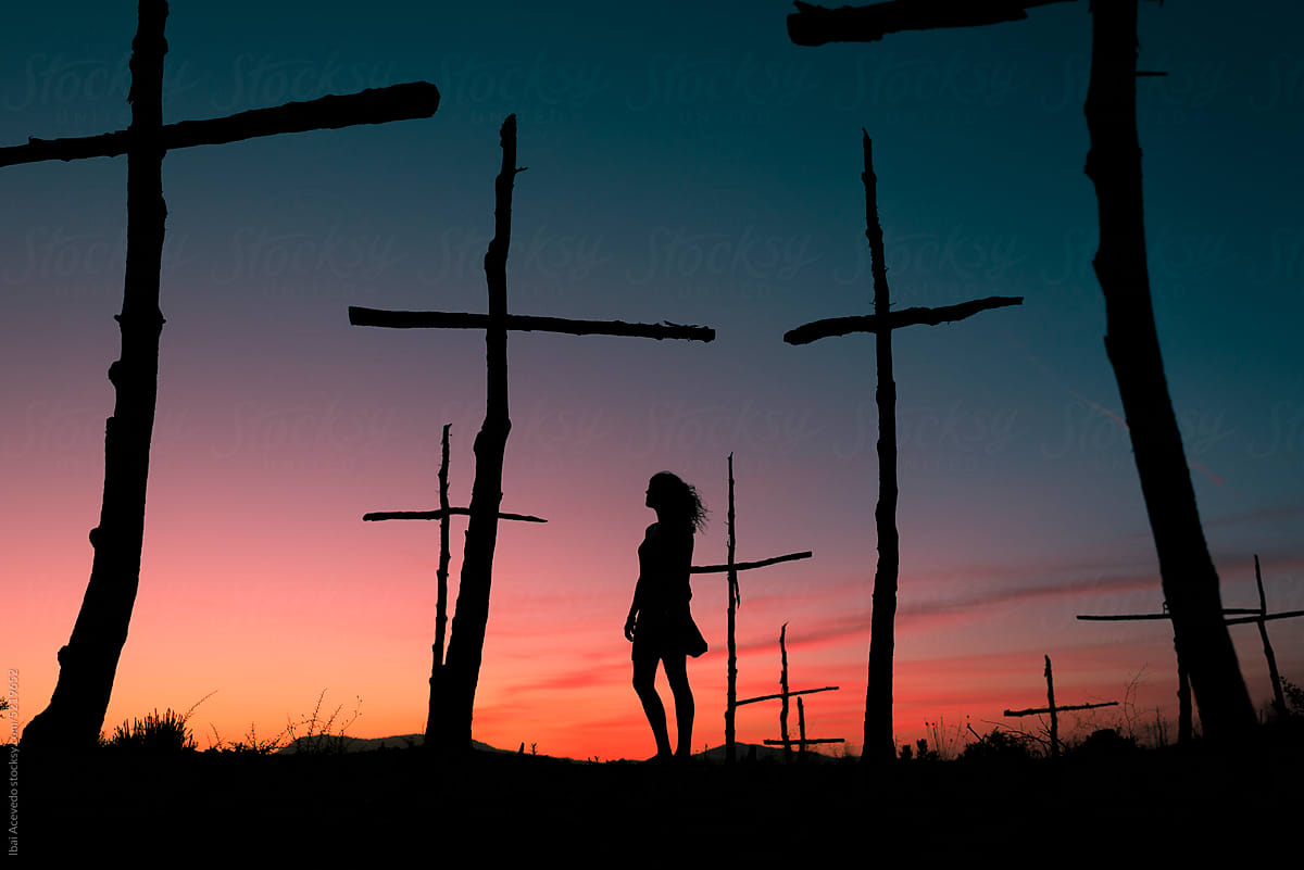 Standing woman silhouette at symbolic trees graveyard