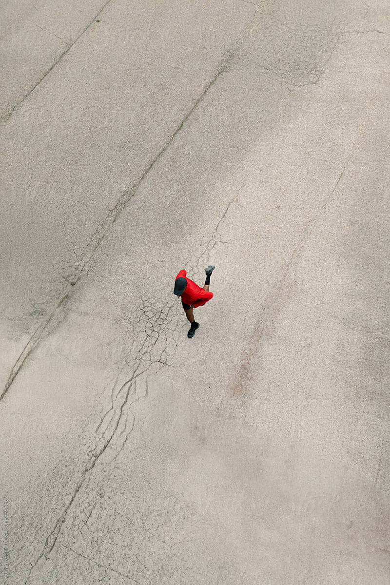 Aerial view of black athlete running on the asphalt of an empty street